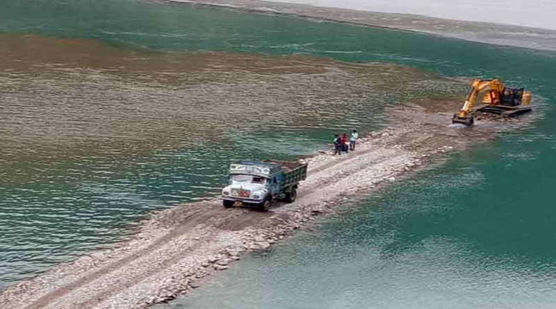 मलबे के साथ झील में समा रही एक सड़क की उम्मीद