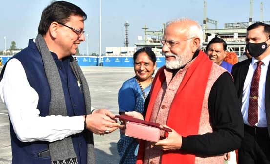 CM dhami present bal mithai to pm modi at jollygrant airport